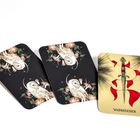 "WARNZEICHEN" auf einer hellen Karte mit Schwert und roten Bändern. Zwei dunkle Karten mit Eulen und Blumen daneben.