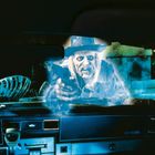 Unten links auf dem Armaturenbrett steht "HY-AMP". Ein gruseliger Geist in einem Cowboyhut zielt durch die Windschutzscheibe.