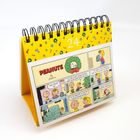 Auf einer gelben Seite mit dem Datum "24" steht ein Aufsteller mit einem Peanuts-Comic darunter.