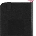 „MOLESKINE“ steht auf einem schwarzen Notizbuch, an dem ein rosa Band mit Karabinerhaken befestigt ist.