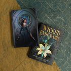 „WICKED ENDEAVORS“ und „KAMILAH COLE“ auf einem Buchcover mit Schwert und Lilie, daneben eine Frau mit Dolch vor einem Fenster.