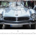 "BMW 507", "CASARES EDITION", darunter Kalenderdaten. Ein silberner Oldtimer mit charismatischem Design in einem Ausstellungsraum.