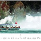 Schweiz, Rheinfall Schaffhausen. Ein Boot mit Menschen fährt vor einem großen Wasserfall, eine Schweizer Flagge weht.