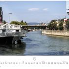 Donaukanal, darunter Zahlen von 1 bis 30. Ein breites Gewässer mit einem weißen Boot links und einer Brücke im Hintergrund.