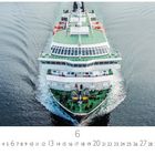 "Hurtigutenschiff auf See" über einem grünen Deck voller Passagiere, die auf breiten Gewässern fahren.