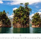 Cheow Lan Lake, Khao Sok Nationalpark. Drei bewachsene Kalkfelsen ragen aus dem blauen Wasser unter blauem Himmel.