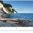 National Park Jasmund, Rügen. Küste mit weißen Klippen, blauem Meer, Kieselstrand und Treibholzstämmen.