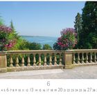 Insel Mainau. Juni-Kalenderblatt. Blühende Pflanzen in Steinvase, Seeblick und Bäume im Hintergrund.