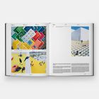 Text oben: "LOCATION", "CLIENT", "PROGRAM"
Buntes Gebäude in LEGO-Stil. Menschen auf gelbem Boden und Treppen.