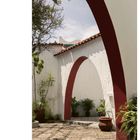 Seite 45. Casa Gustavo Cristo. Arkaden mit roten Bögen, Pflanzen und ein gepflasterter Innenhof unter freiem Himmel.