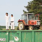 Text: "8070 STEYR", "236", "UDB". Zwei Personen in weißen Anzügen stehen neben einem roten Traktor.