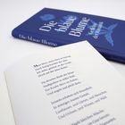 Text: "Die blaue Blume" auf einem Buch mit blauem Einband. Offene Seite zeigt ein Gedicht, beginnend mit "Mein Herz, mein Herz".