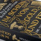 Eleanor Barraclough: "Im Schein von Gold und Feuer". Schwarz-goldener Buchrücken mit wikingerzeitlichen Symbolen.