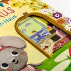 Buchcover mit Texten: "MAUS", "ein nach Haus", "über 40 Klappen und 60 Suchaufg.". Illustration einer Maus mit Blumen.