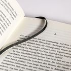 Seite eines offenen Buches, Kapitelnummer "3", mit einem schwarzen Lesezeichenband.