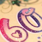 Der Text "60" ist in bunten, glitzernden Buchstaben gestaltet. Verschnörkelungen und Sterne umgeben den Text.