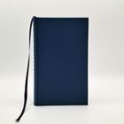 Ein schlichtes blaues Buch mit einem langen, schwarzen Lesebändchen hängt seitlich heraus.