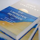 Cover eines Buches mit dem Titel „DIE 1-MINUTEN METHODE“ von John Strelecky, Verlag dtv, in Blau und Gold.