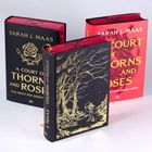 Drei Bücher von Sarah J. Maas. Titel: "A Court of Thorns and Roses". Eines zeigt eine goldene Waldszene.