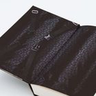 Ein aufgeschlagenes Buch mit dunklem Muster und angedeuteten Schnallen wie Sicherheitsgurte.