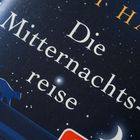 Text: "Die Mitternachtsreise". Sternenhimmel mit Katze und Halbmond.