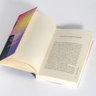 Ein aufgeschlagenes Buch zeigt die Seite mit der Überschrift "EIN MATCH, MADE IN HEAVEN". Links liegt der bunte Buchumschlag.