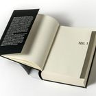 „TEIL 1“ auf einer Buchseite. Links ein schwarzer Text auf der Innenseite des Umschlags. Buch liegt offen.