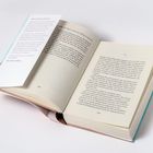 Ein aufgeschlagenes Buch mit einer eingelegten Karte. Die Seiten zeigen Text, darunter Kapitelnummern und Seitennummern.