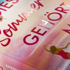 Text: "DIESER SOMMER GEHÖRT MIR". Illustration einer Frau im Badeanzug vor einem bunten Hintergrund.