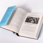 Ein aufgeschlagenes Buch zeigt Text auf Seite 114 und 115, mit einem Foto von Personen in Uniformen auf der rechten Seite.