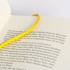 Der Text beschreibt einen stürmischen Moment auf einer Insel. Ein gelbes Leseband liegt auf den Buchseiten.