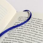 Seite eines Buches mit schwarzem Text und einem blauen Stofflesezeichen in der Mitte der Doppelseite.