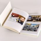 Ein aufgeschlagenes Buch mit Bildern und Texten über persönliche Momente und ein Restaurant, sowie Zerstörung durch Raketen.