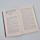 Text: RIVER, KAPITEL 9. Ein Buch liegt geöffnet auf einer hellen Oberfläche. Der Text ist in Schwarz gedruckt.