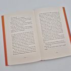 Text auf den Seiten 134-135; ein geöffnetes Buch mit rotem Einband liegt auf einer weißen Oberfläche.