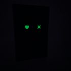 Leuchtendes Herz- und X-Symbol auf schwarzem Hintergrund.