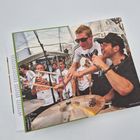 Ein Mann mit Sonnenbrille trommelt auf ein Schlagzeug, umgeben von jubelnden Menschen in Fußballtrikots.