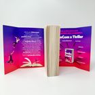 Ein aufgeschlagenes Buch mit violett-rotem Hintergrund. Zwei springende Personen, ein offenes Buch mit einem Messer.