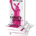 „Marc-Uwe Kling, Die Känguru-Rebellion“, pinkes Känguru mit Boxhandschuh hochhaltend. Bücherstapel.