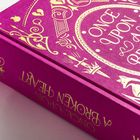 „ONCE UPON A BROKEN HEART“ steht in eleganter goldener Schrift auf einem lila Buchcover mit dekorativen Mustern.