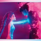 Illustration mit zwei Figuren: Eine Frau mit langer Zöpfe und ein Mann mit Hut in neonfarbenem Licht vor rosa Hintergrund.