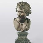 Büste eines jungen Mannes mit lockigem Haar, aus Bronze, auf einem marmorierten Sockel.