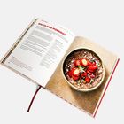 Text: "Bauch-weg-Porridge". Foto eines Porridge mit Erdbeeren und Nüssen in einer Schüssel auf einer Buchseite.