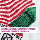 HERZCHENFERSE & VERSTÄRKTE FERSENWAND FÜR PERFEKTE PASSFORM. Nahaufnahme eines gestrickten Sockenabschnitts in Rot, Weiß, Grün.