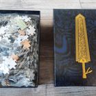 "P-Bandai". Links eine Schachtel mit Puzzle-Teilen, rechts ein Deckel mit einem goldenen Schwert auf dunklem Hintergrund.