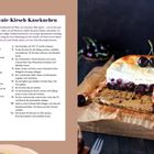 "Brownie-Kirsch-Käsekuchen" - Rezepttext und Bild eines saftigen Kuchens mit brauner Kruste, hellen Schichten und Kirschen.