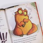 „Hicks?“ Text über Drachenbekämpfung. Illustration eines kugeligen, orangefarbenen Drachen mit großem Bauch und rauchenden Ohren.