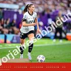 "Vorjahresabbildung" in großen Buchstaben. Eine Fußballspielerin im weißen Trikot läuft mit einem Ball auf dem Spielfeld.