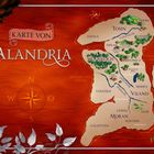 "Karte von Alandria", fantasievolle Karte mit Orten wie Woodloch, Tosin und Moran, umrahmt von Blättern und Kompassrose.