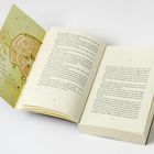 Links eine Karte mit Orten wie „Auberge“ und „Café“. Rechts offene Buchseiten mit fortlaufendem Text.